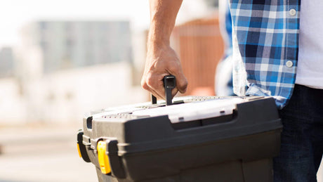 Close up of a man carrying a tool box
